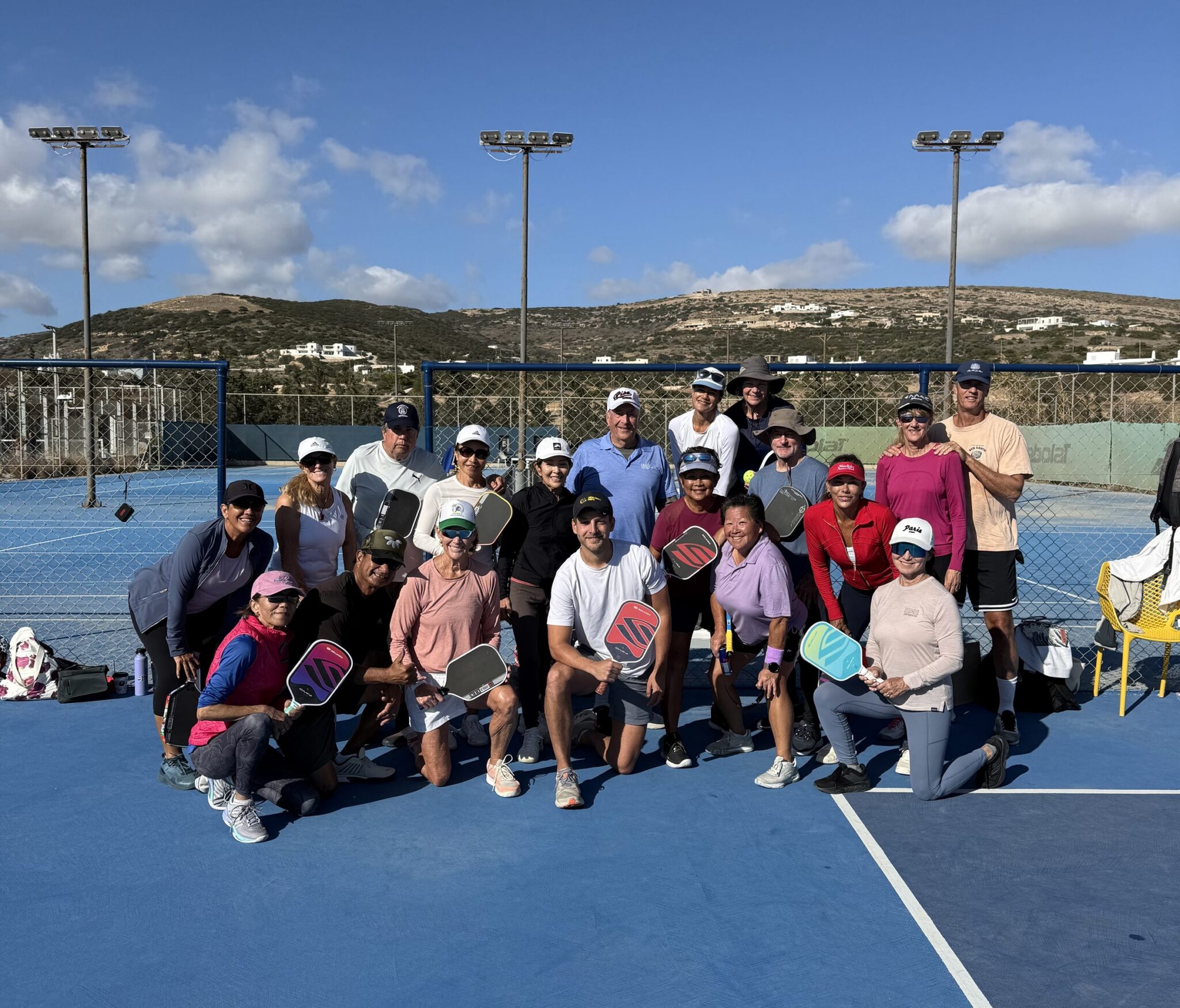 A Pickleball Trips group with their paddles on an outdoor court